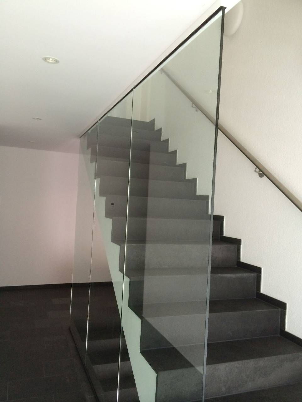 Ein Mann steht auf einer Leiter und repariert eine Dachrinne an einem Haus.