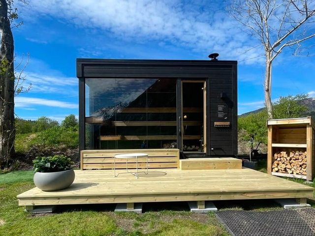 The black wooden sauna with a large glass front at Åndalsnes camping