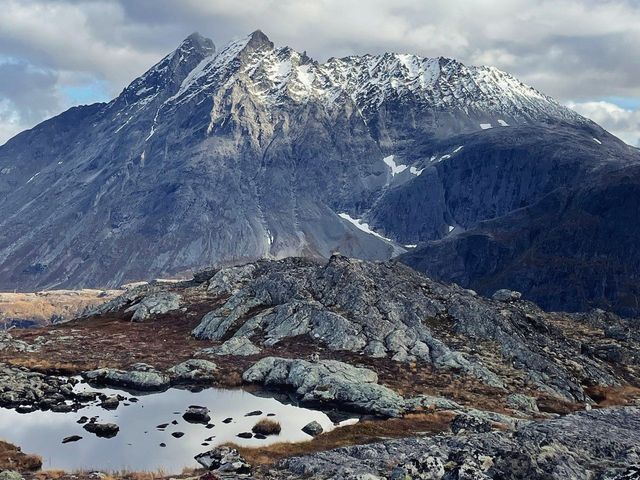 Snow-capped peaks and a mountain tarn seen from the Norafjellet hike