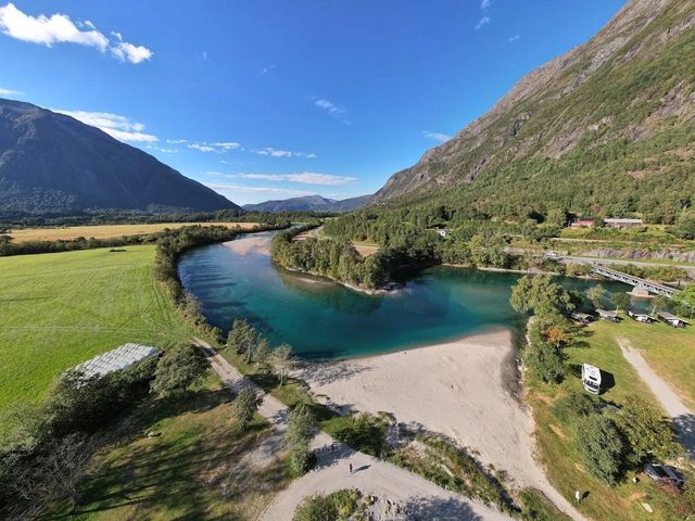 Aerial view of the sandy beach and turquoise river at Sogge, below steep green mountains