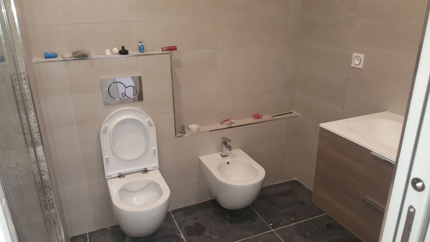Un bidet et des WC suspendus installés dans une salle de bains.