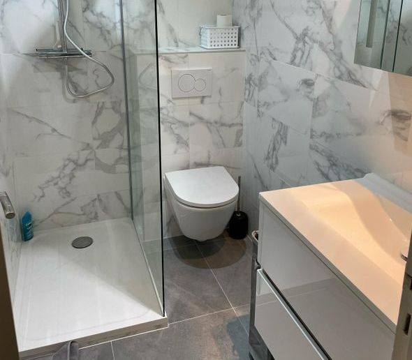 WC suspendus installés à côté d'une douche.