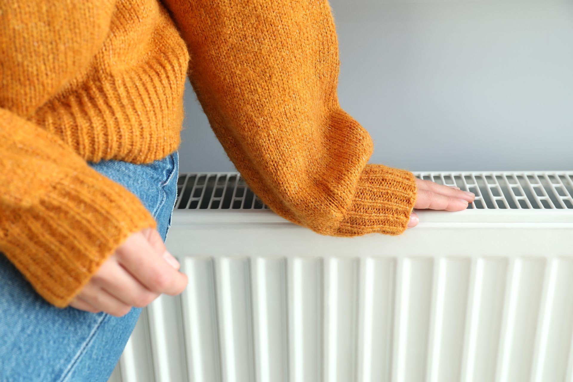 Une femme assise sur un radiateur à eau chaude.