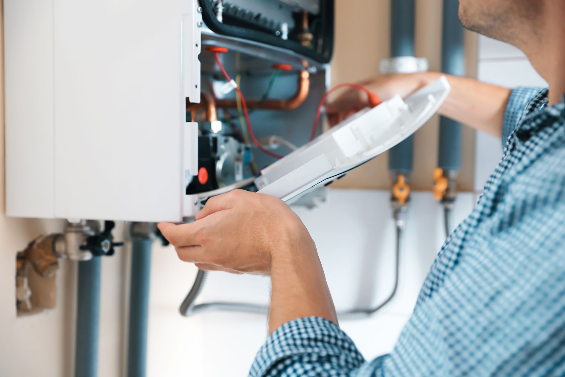 Gros plan sur les mains d'un professionnel qui ouvre le couvercle d'une chaudière. 