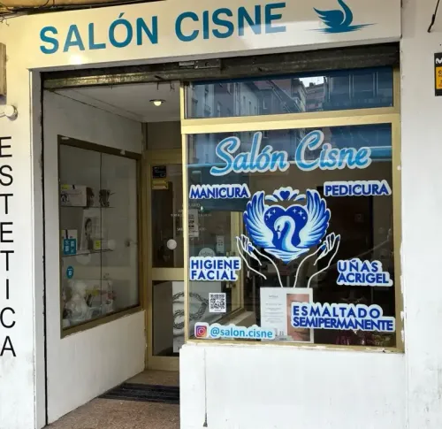 Interior de un salón de uñas con un logotipo de cisne en la pared y una estación de manicura.