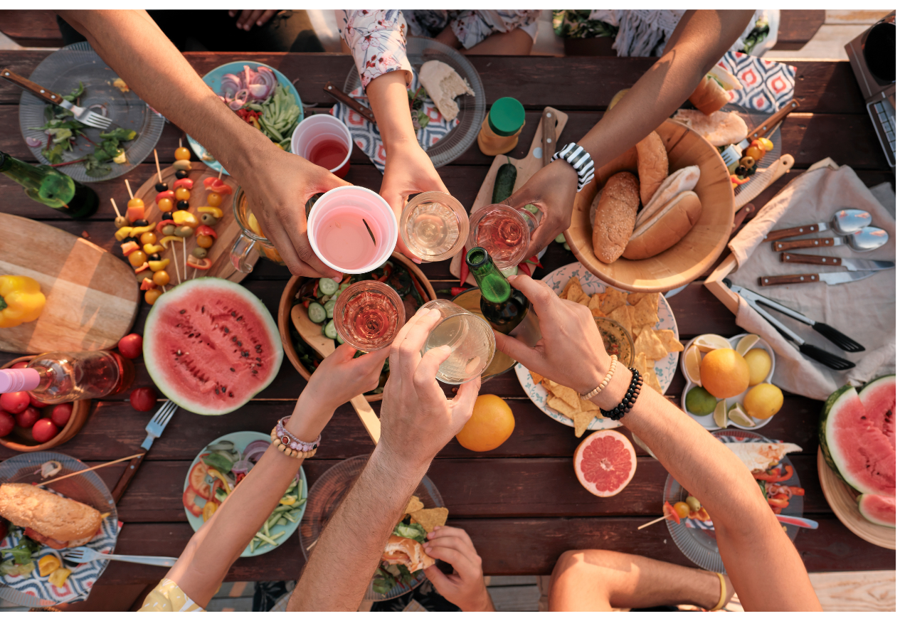 Des mains au-dessus d'une table remplie de nourriture