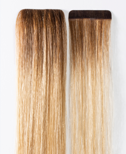 Dos mechones de cabello se encuentran uno al lado del otro sobre una superficie blanca.