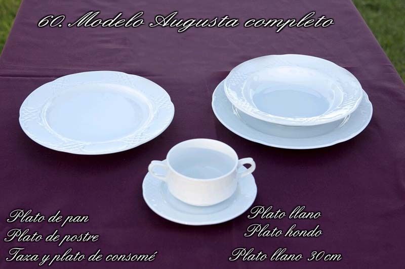 Un juego de platos y tazas blancos sobre un mantel morado.