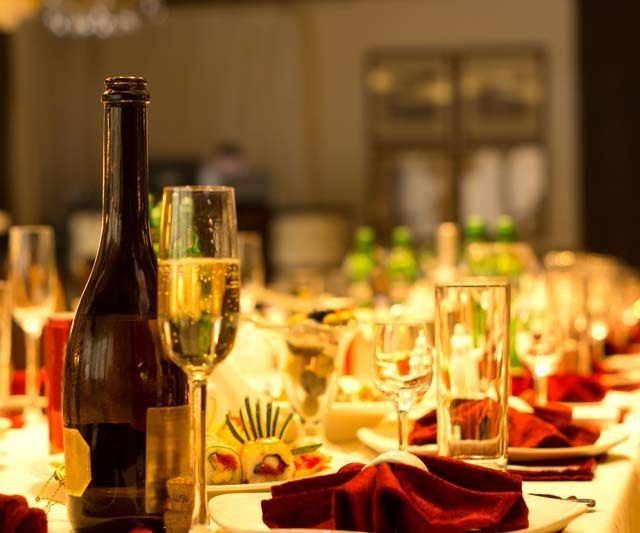 Una botella de vino está sobre una mesa al lado de una copa de vino.