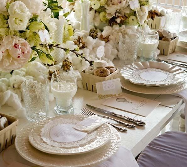 Una mesa con platos y cubiertos y flores sobre ella.