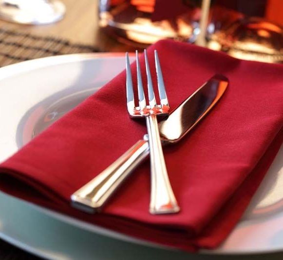 Cubiertos sobre una servilleta roja en un plato