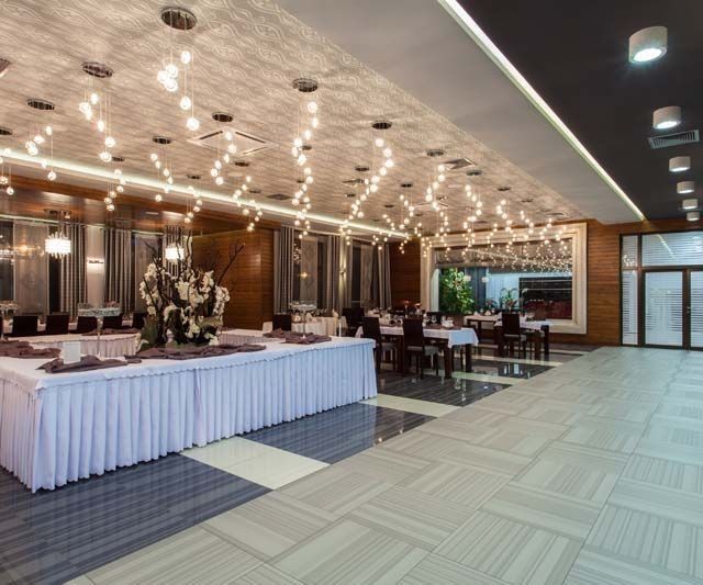Una gran sala con mesas y sillas preparadas para un banquete.