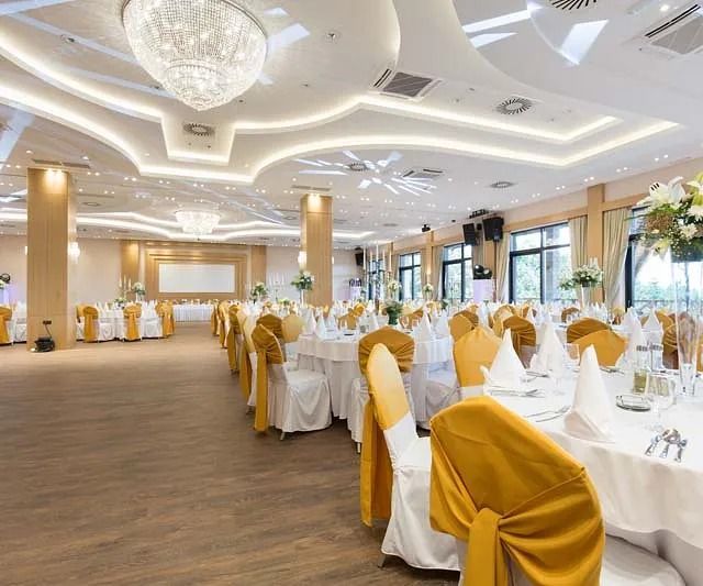Una gran sala con mesas y sillas preparadas para una recepción de boda.