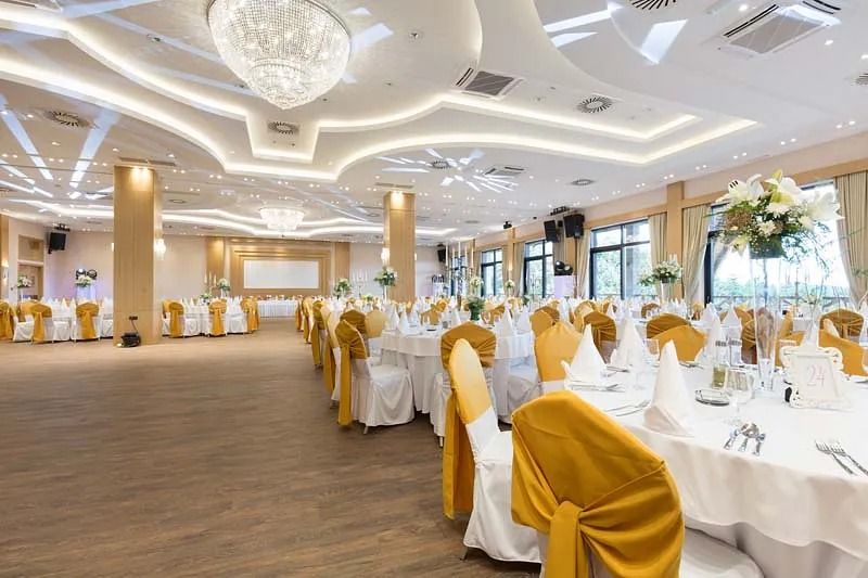 Una gran sala con mesas y sillas preparadas para una recepción de boda.