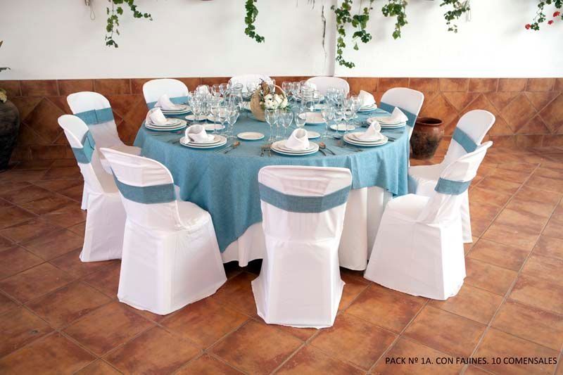 Una mesa redonda con un mantel azul y sillas blancas.