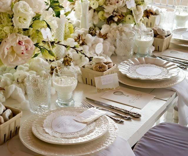 Una mesa con platos, cubiertos y flores sobre ella.