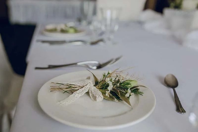 Un plato blanco con un ramo de flores está sobre una mesa.