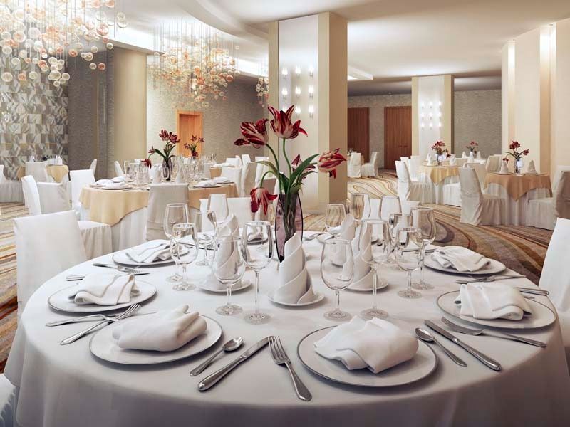 Una gran sala con mesas y sillas preparadas para una recepción de boda.