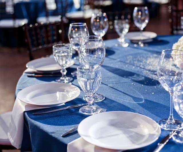 Una mesa con platos, copas de vino y cubiertos sobre ella.