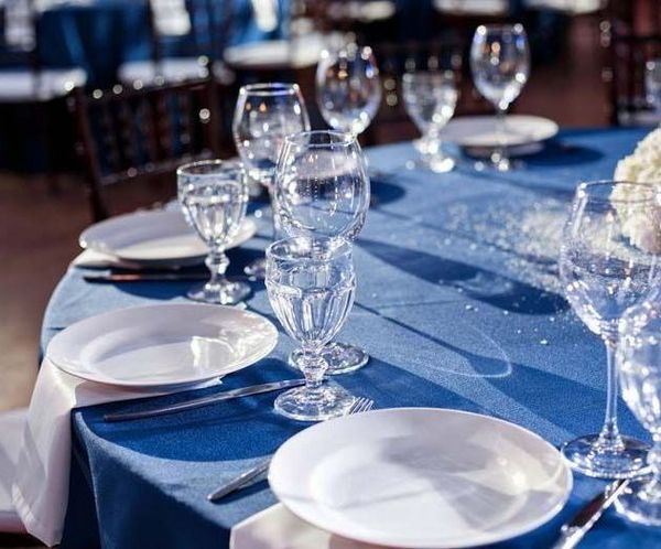Una mesa con platos, copas de vino y cubiertos sobre ella.