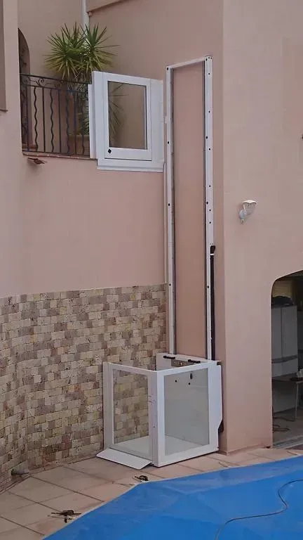 Élévateur contre un bâtiment rose