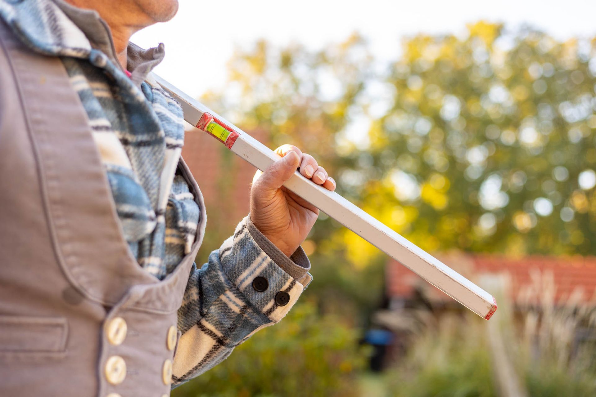 Ein Mann hält eine Wasserwaage in der Hand.