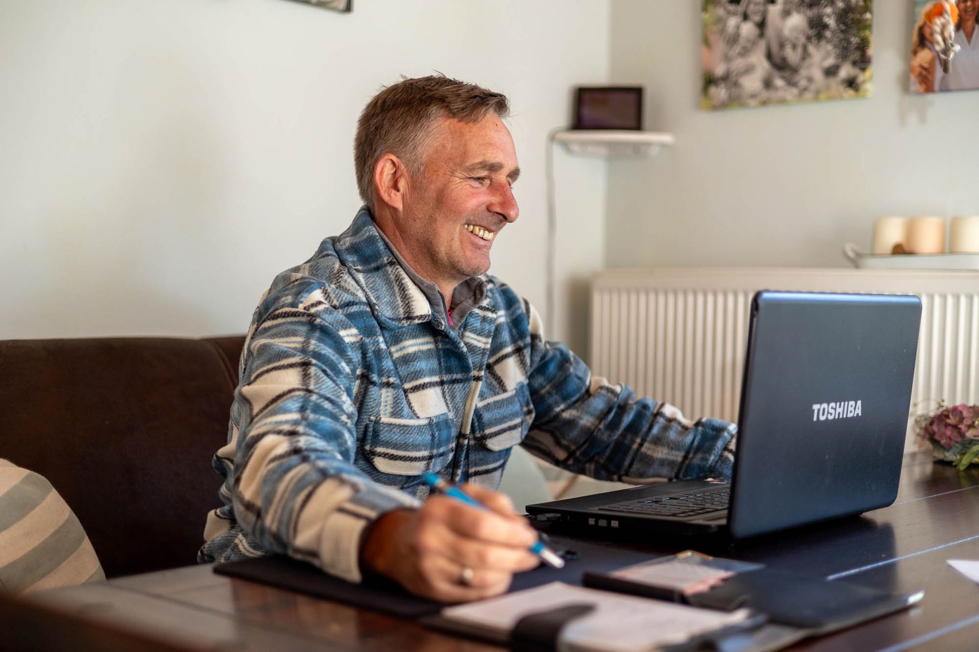 Ein Mann sitzt an einem Tisch und benutzt einen Laptop.