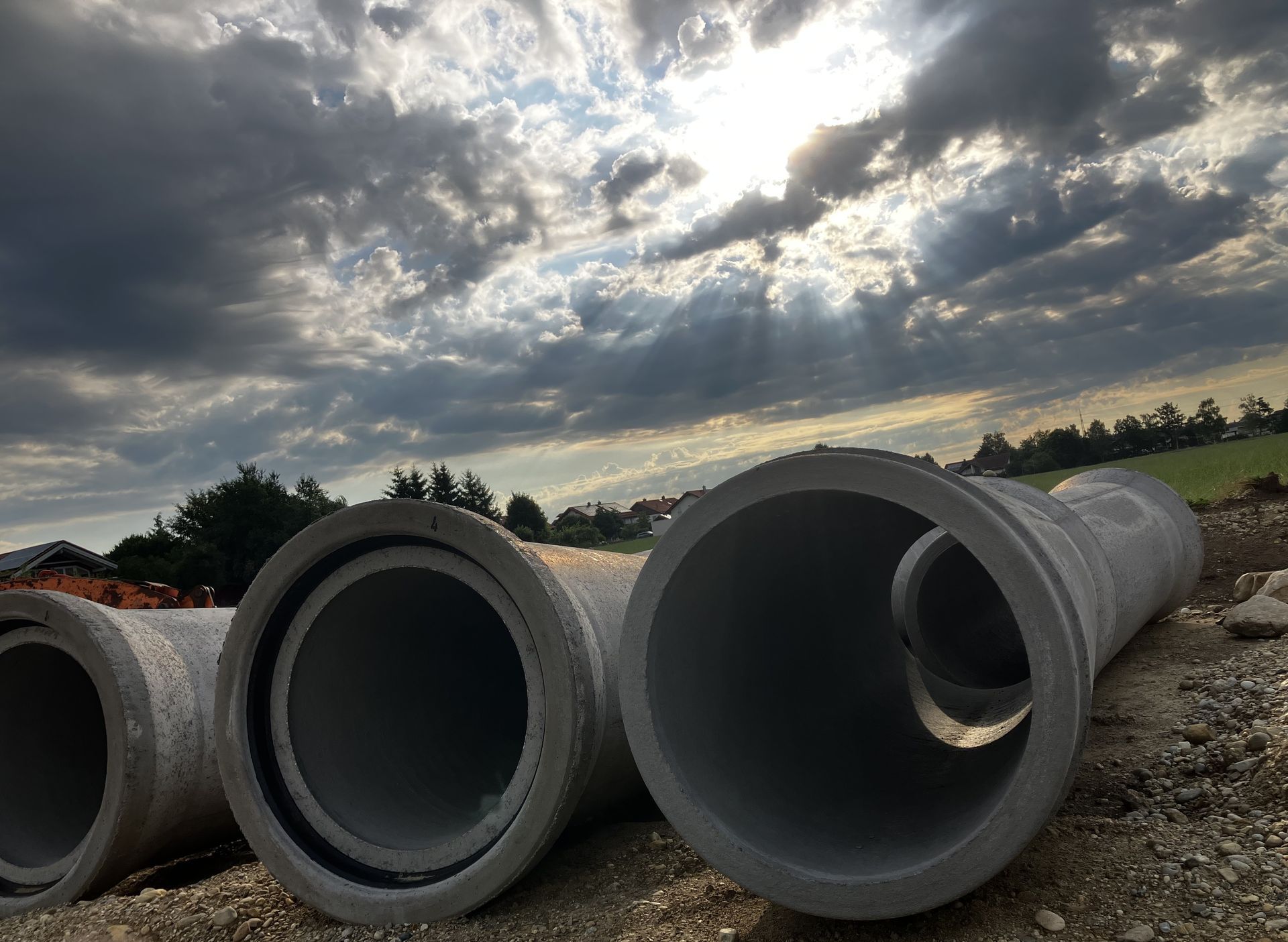Große Betonrohre auf Baustelle unter Wolkenhimmel