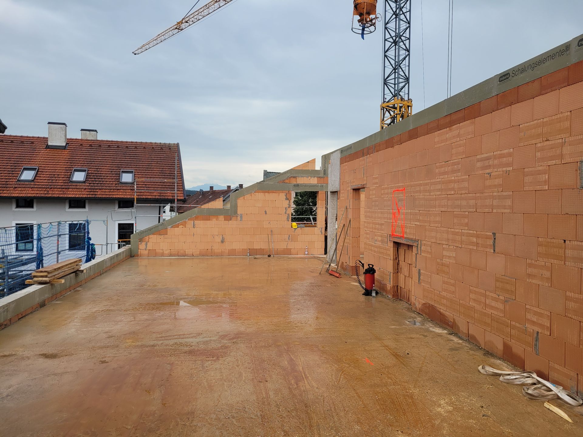 Baustelle mit gemauerten Ziegelwänden und Baukran