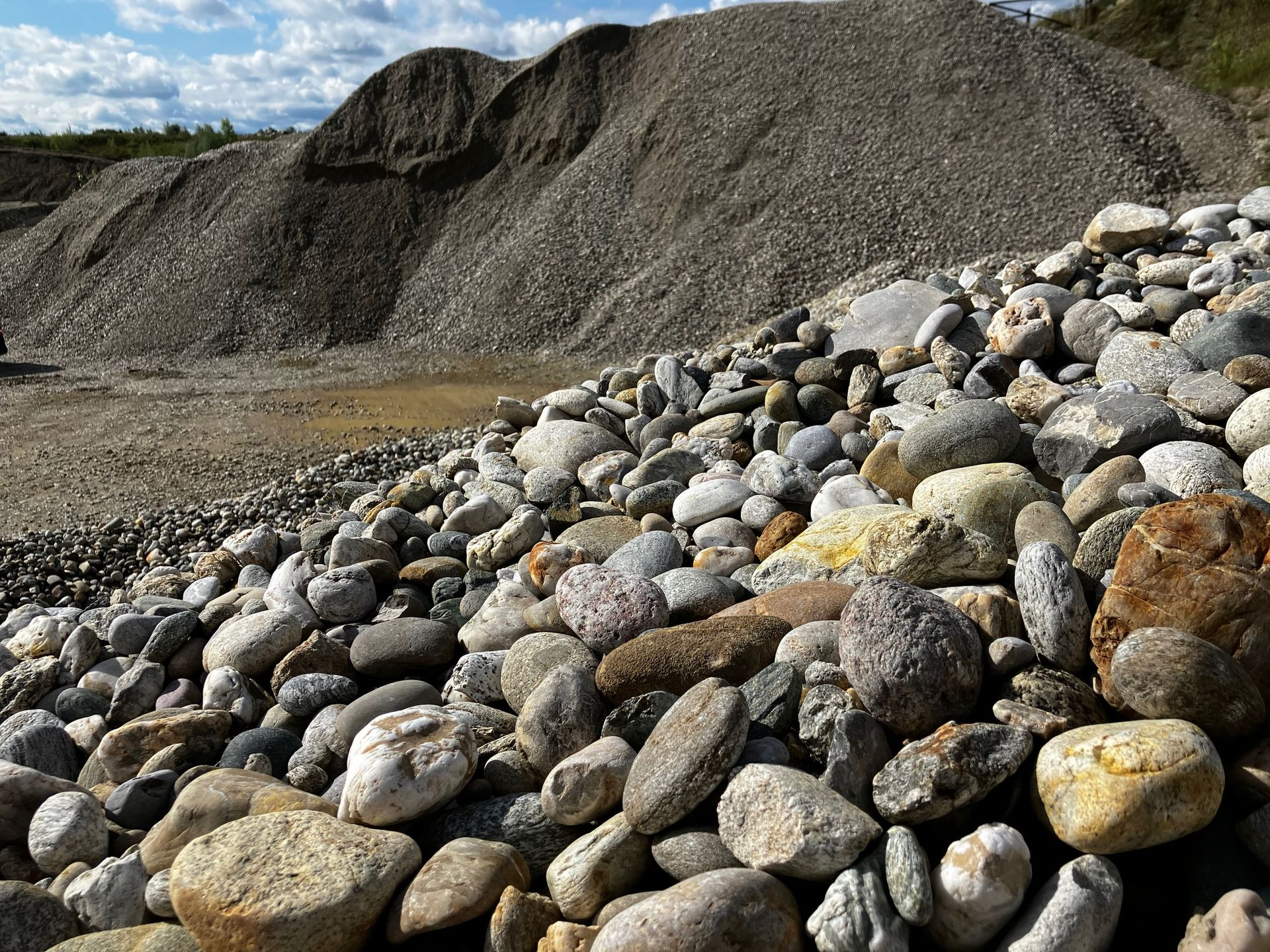 Kieshalde mit großen Steinen im Vordergrund