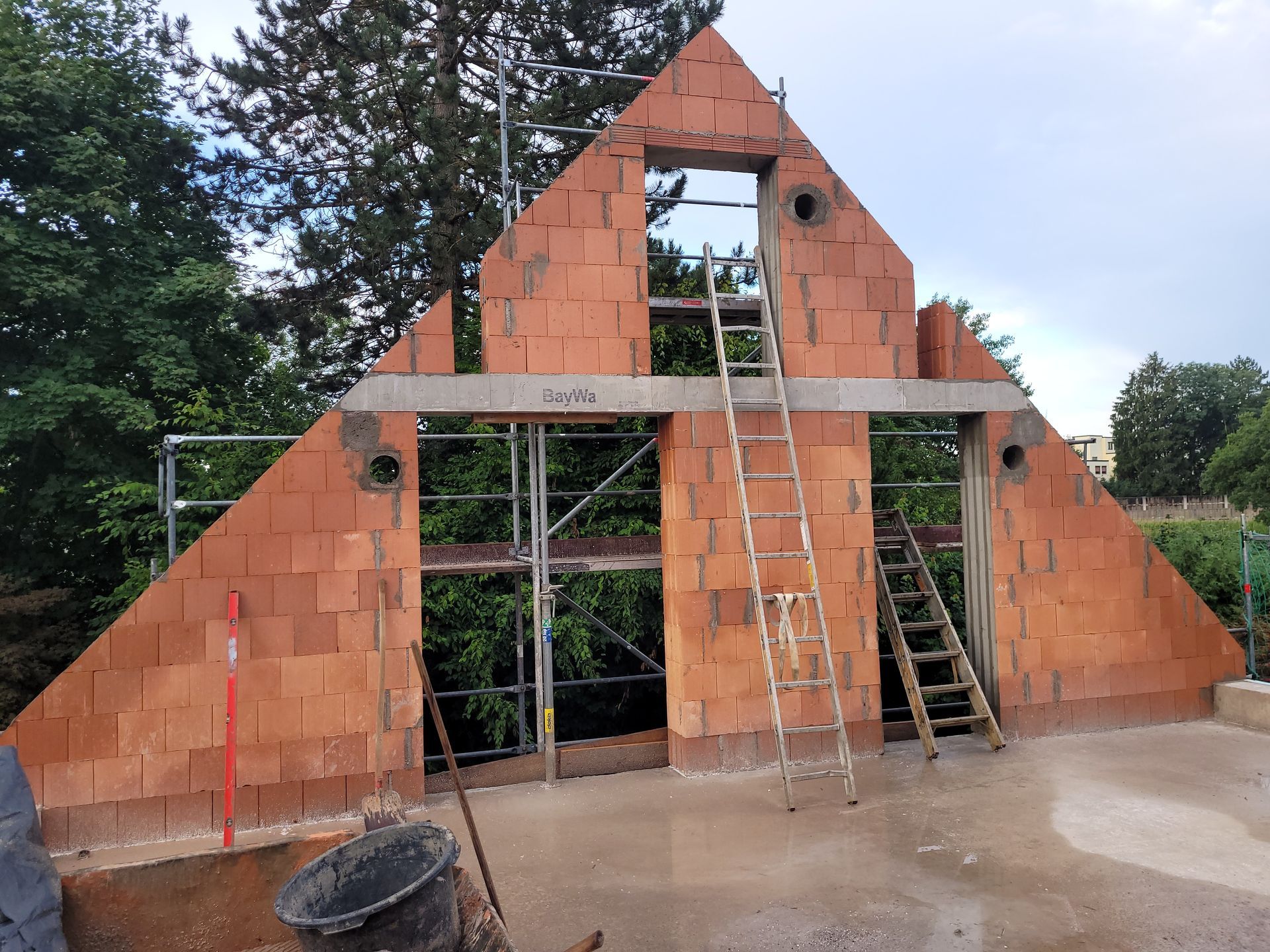 Ziegelgiebel in Dreiecksform mit Gerüst und Leiter