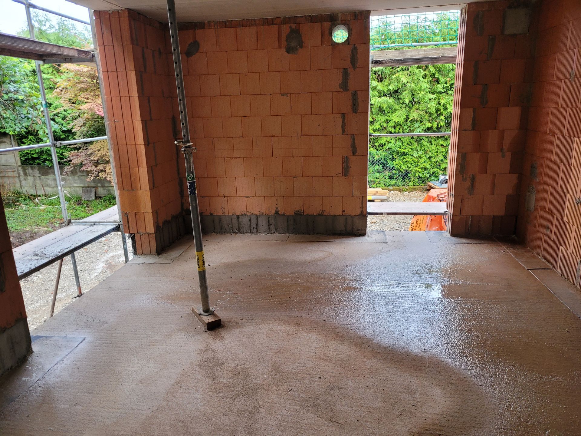 Innenansicht eines Rohbaus mit Stütze und Ziegelwänden