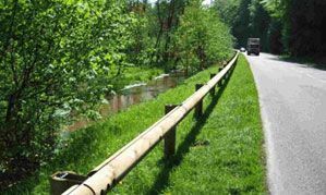 Un camión circula por una carretera al lado de una valla de madera.