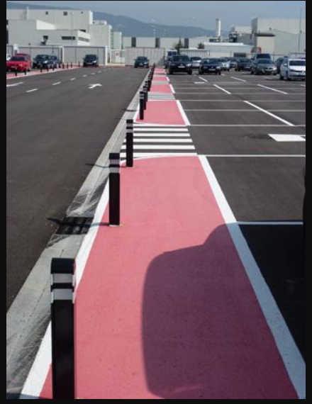 Un estacionamiento con autos estacionados al costado de la carretera.