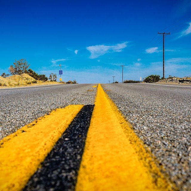 Un primer plano de una línea amarilla al costado de una carretera.