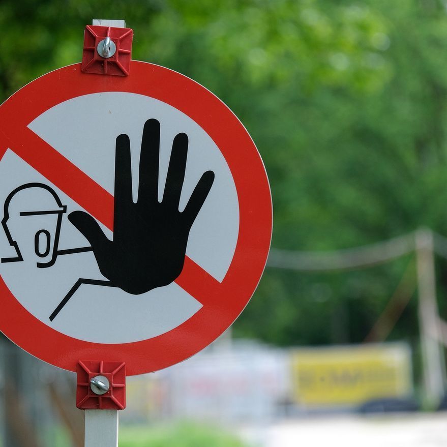 Una señal de no entrada con una mano en el medio