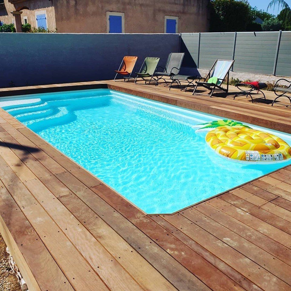 Une piscine avec une terrasse boisée
