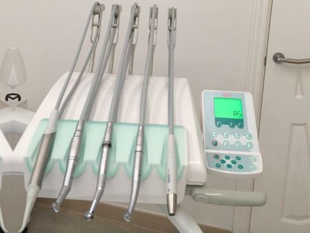 Una silla dental con instrumentos y una pantalla que dice 'rs'