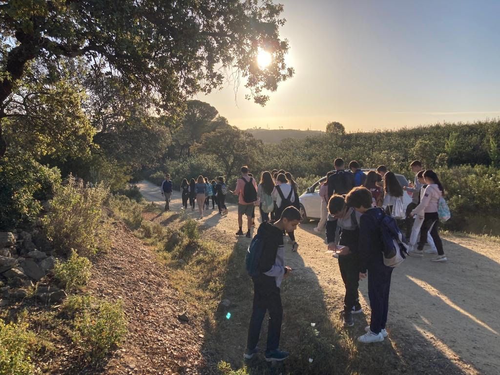 Un grupo de personas están paradas en un camino de tierra.