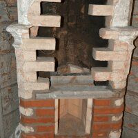 Brick fireplace with a dark firebox opening and stacked light stone surround