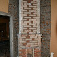 Partially finished brick chimney in an unfinished interior wall