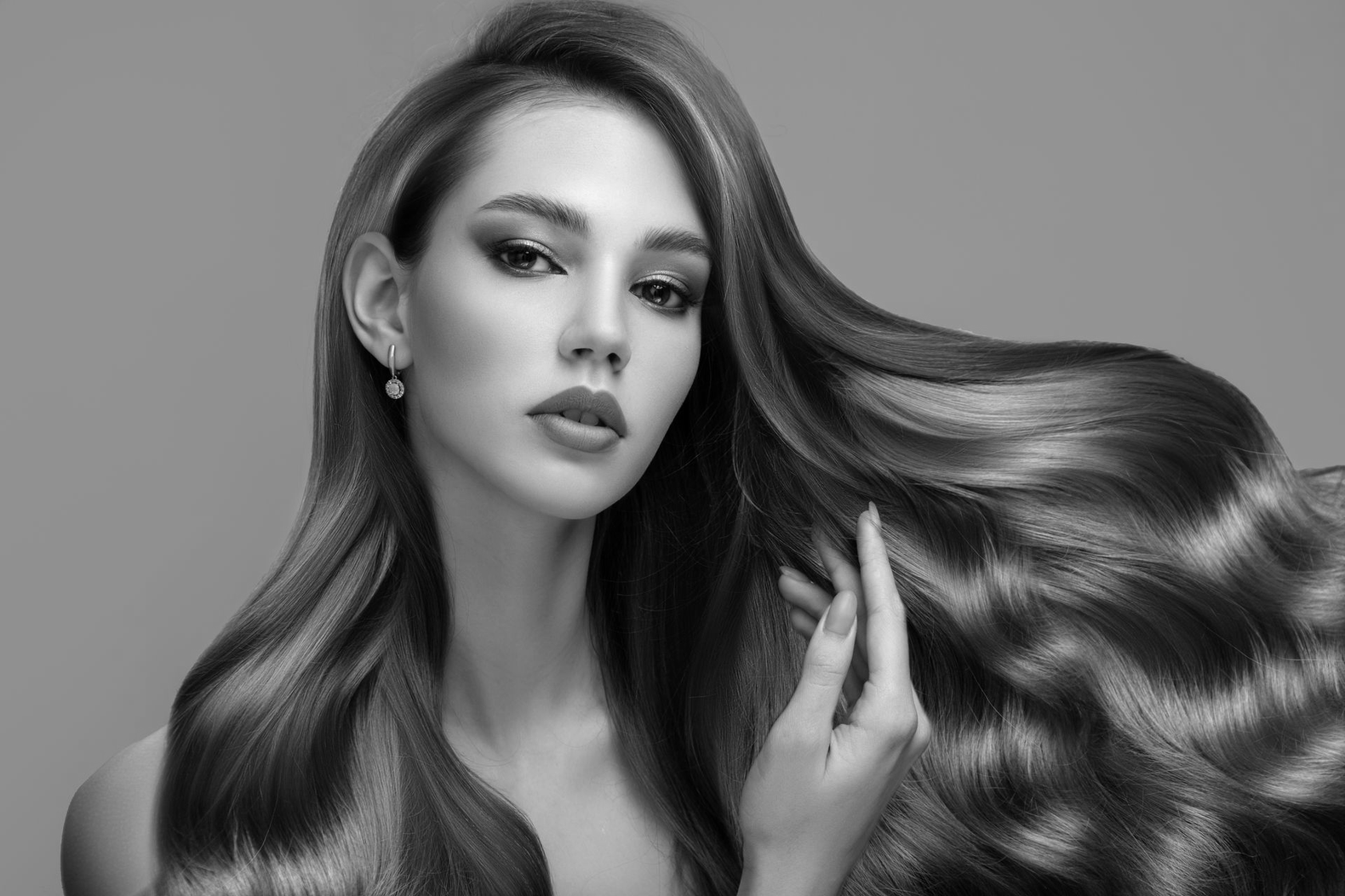 Retrato en blanco y negro de una mujer con cabello largo y suelto, mirando a la cámara.