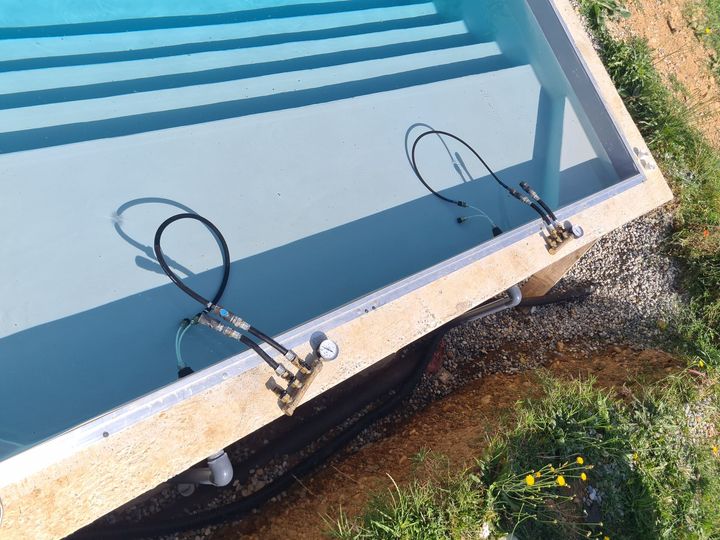 Deux compresseurs au bord d'une piscine.