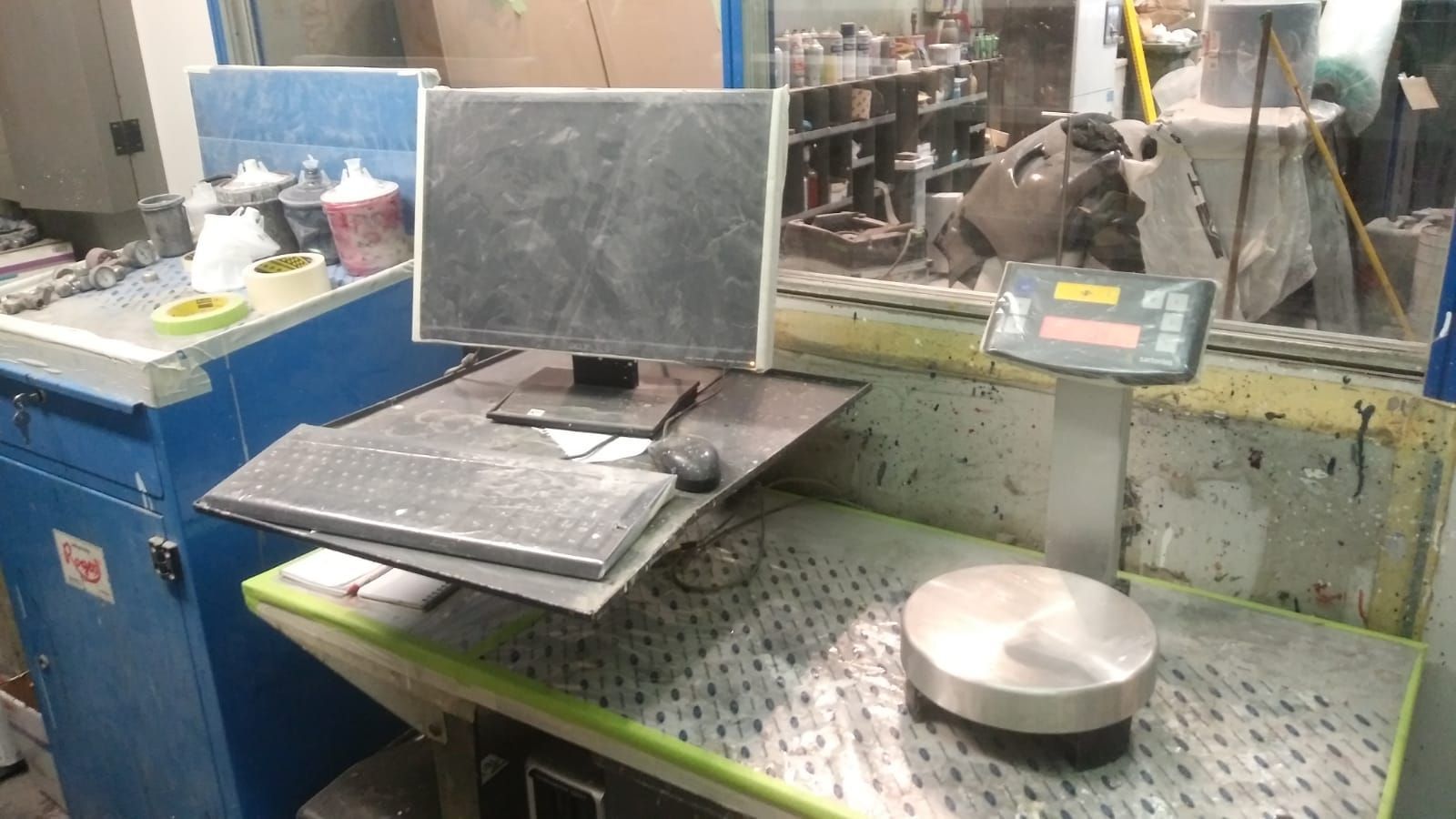 Una computadora está colocada encima de un escritorio en una fábrica.