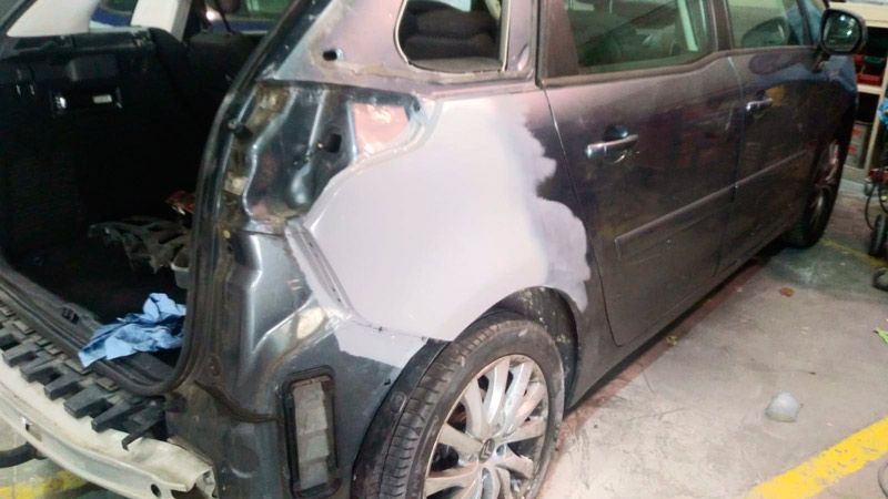 Se está pintando un coche en un garaje.