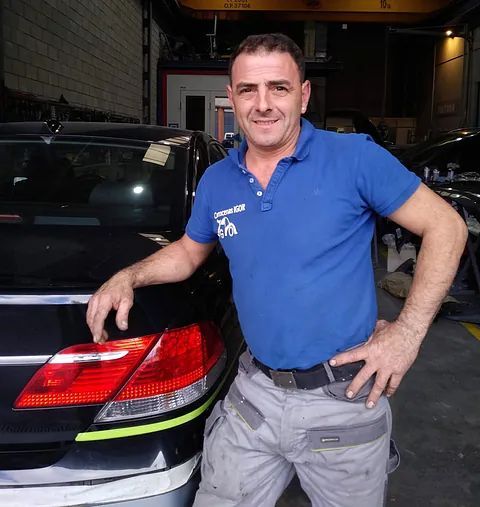 Un hombre con una camisa azul con la palabra eh escrita en ella.