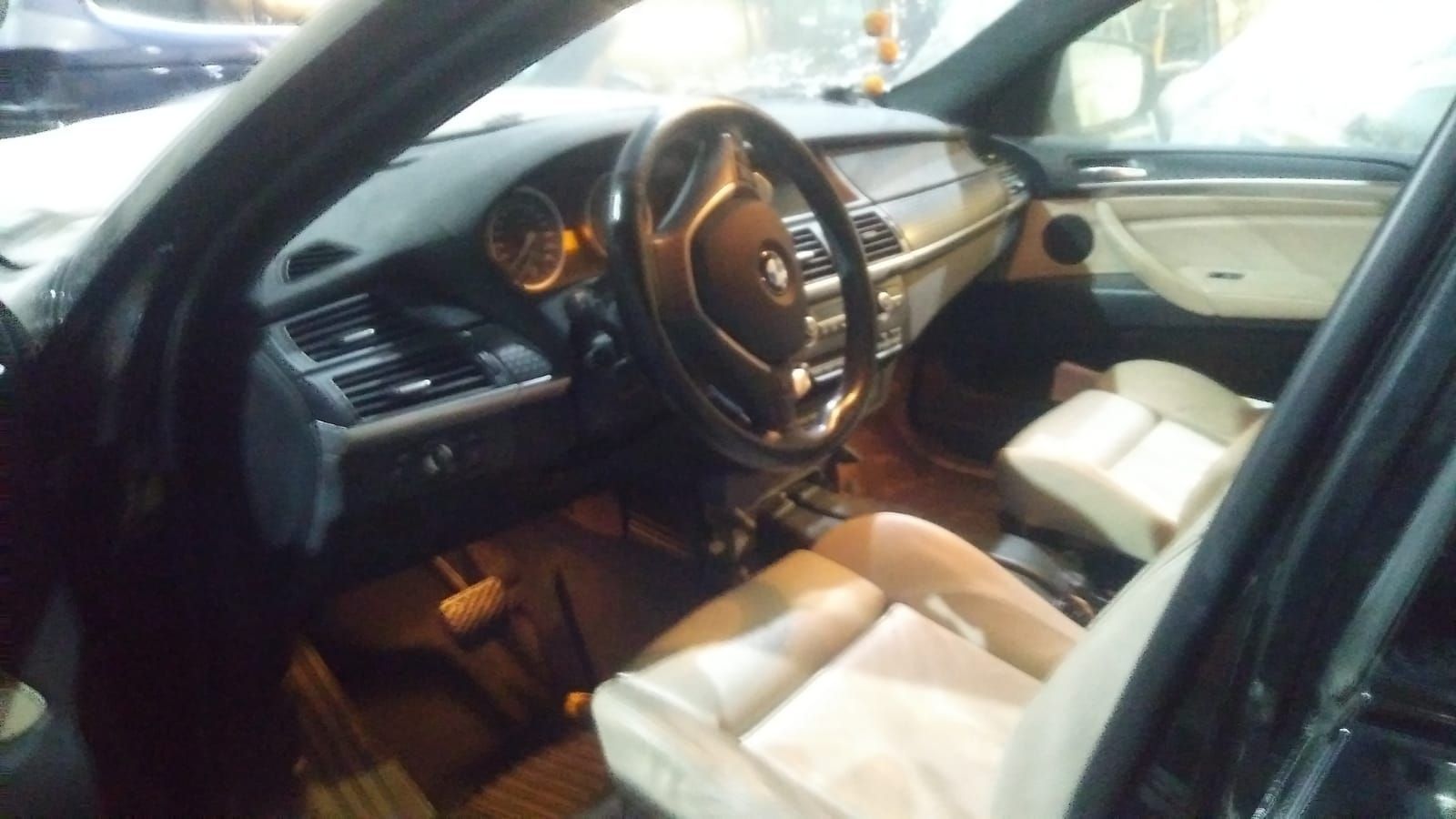 El interior de un coche con la puerta abierta y el volante visible.