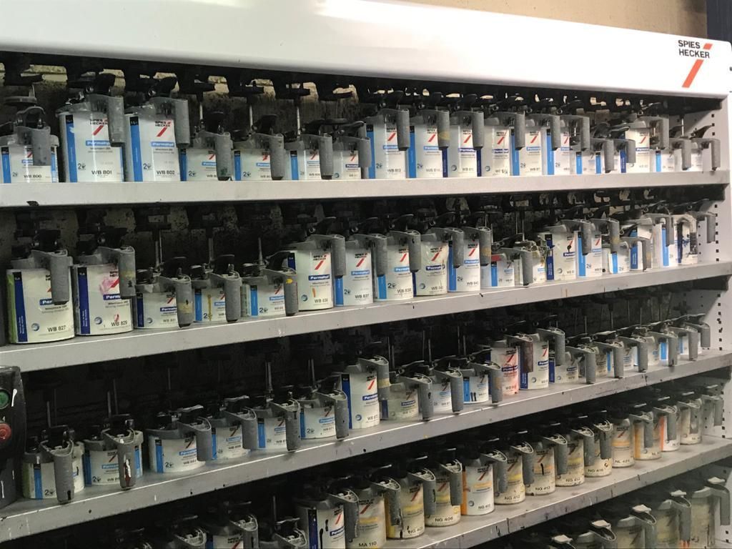 Un estante lleno de muchas latas de pintura.