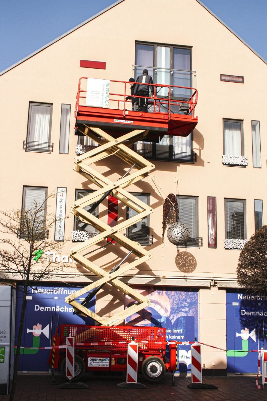 Handwerker auf Hebebühne reparieren ein kaputtes Fenster