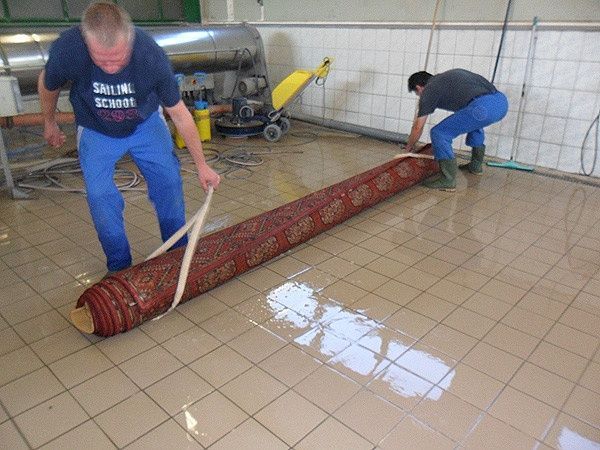 Ein Mann reinigt einen Teppich